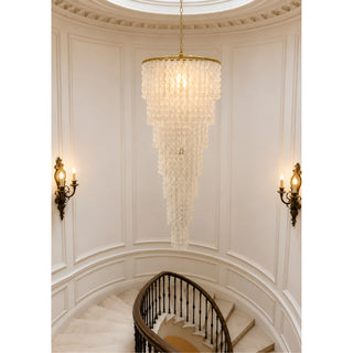 Nacara capiz shell cascade chandelier in a domed rotunda stairwell with brass wall sconces