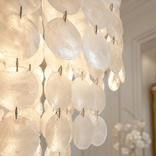 Close-up of the natural capiz shell discs on the Nacara chandelier catching warm light