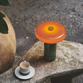 Nordic portable marble table lamp with orange glass shade on stone table with coffee cup