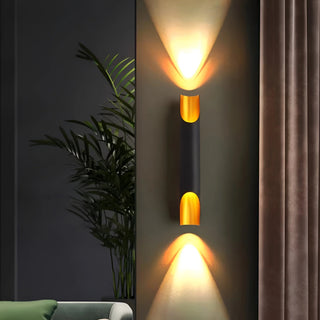 Black and gold wall sconce glowing warmly in a modern living room setting