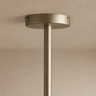 Close-up of the Novara brass canopy and stem against a warm ceiling