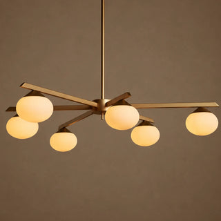 Novara brass six-light opal-globe chandelier, warm angled studio view