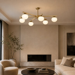 Novara brass opal-globe chandelier glowing over a living room with a fireplace