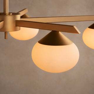 Close-up of a Novara opal glass globe and brass cone cap on a radial arm