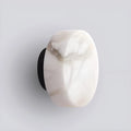 Close-up of Spanish onyx wall light with matte black base