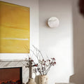 Natural onyx sconce lighting up modern living room with art and fireplace