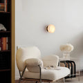 Warm onyx wall light with soft glow in minimalist reading corner