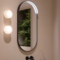 Set of French onyx wall lights mounted beside oval bathroom mirror