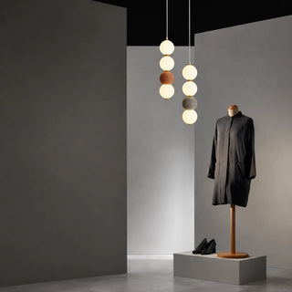 Orbara stacked-sphere pendants in brick red and gray displayed in a boutique retail setting