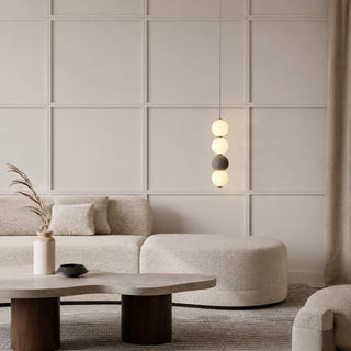Gray Orbara stacked-sphere pendant hanging in a neutral living room above a stone coffee table