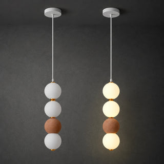Orbara stacked-sphere pendant with a brick-red micro-cement bead, shown lit and unlit on a dark background