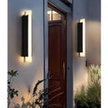 Two modern LED wall lights installed at main entryway with warm ambient glow