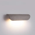 Side view of gray concrete wall light glowing warmly on a plain background