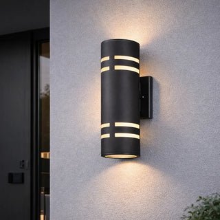 Modern LED wall sconce glowing on a gray exterior wall with sleek architectural design