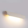 Wide-angle view of white curved wall light illuminating a surface with warm light