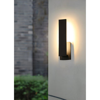 Daytime view of black modern wall light installed on white wall