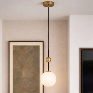 Close-up of a globe pendant light with brass fixture in a clean, contemporary space
