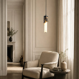 Pietrara marble pendant light glowing beside an armchair in an elegant panelled living room