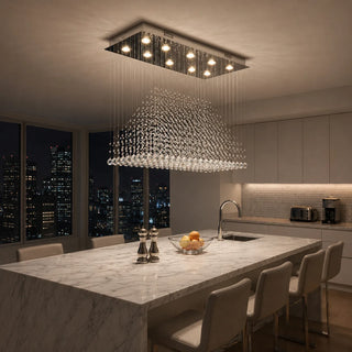Piovara crystal raindrop chandelier over a marble kitchen island in a warmly lit modern apartment at night