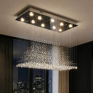Piovara crystal rain chandelier in a modern living space with floor-to-ceiling windows at night