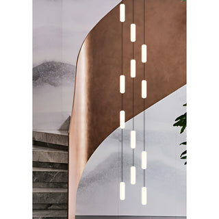 Pluvara capsule cascade chandelier against a curved copper wall in a duplex stairwell
