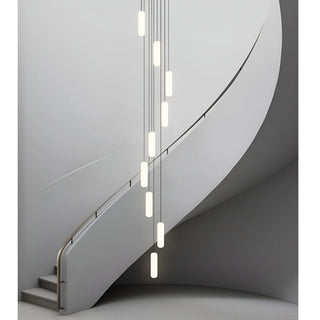 Pluvara capsule LED chandelier tracing a curved minimalist stairwell in soft grey tones