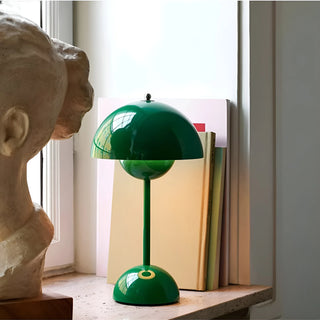 Modern signal green portable mushroom table lamp with rechargeable LED placed on window shelf