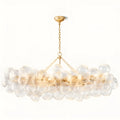 Modern rectangular chandelier with clear ribbed glass globes and gold frame on neutral background.