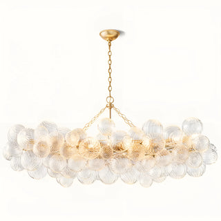 Modern rectangular chandelier with clear ribbed glass globes and gold frame on neutral background.