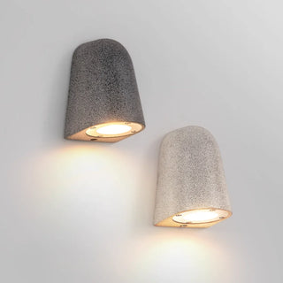 Set of white and black sandstone microcement wall lamps with warm LED lighting