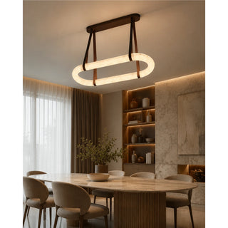 Sellara alabaster oval chandelier lighting a bright modern dining room with a marble table and sheer curtains