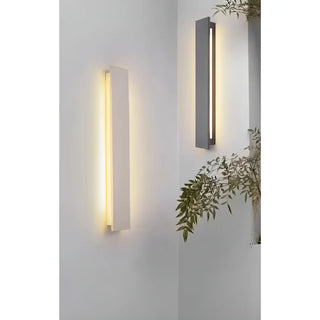 Black and white minimalist outdoor wall sconces installed side by side on a white modern exterior wall.