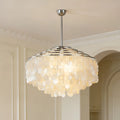 Silver capiz shell chandelier hanging in a modern living room with warm ambient lighting