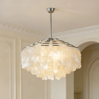 Silver capiz shell chandelier hanging in a modern living room with warm ambient lighting