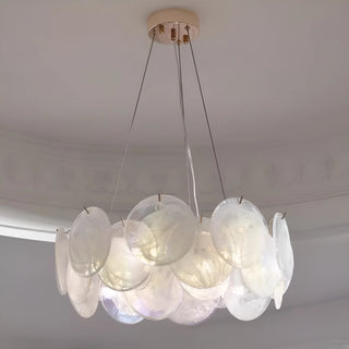 Modern round glass chandelier in soft white finish installed in elegant dining room interior