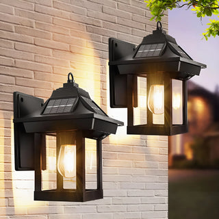 Pair of vintage-style solar wall lanterns lighting up a patio wall at dusk