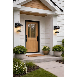 Front porch decorated with two solar-powered black wall lanterns on either side of the door