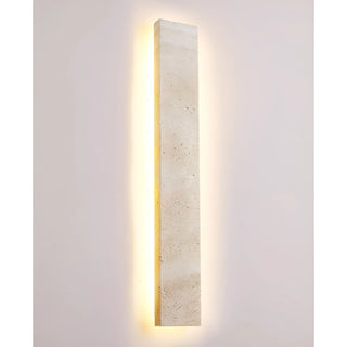 Full frontal view of Solea wall sconce with integrated LED softly highlighting natural stone