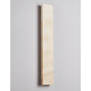 Unlit Solea sconce in full view showcasing pure travertine craftsmanship and geometric form