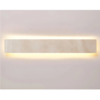 Horizontal-mounted Solea travertine wall light glowing softly against a neutral backdrop, showcasing natural stone elegance