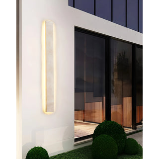 Illuminated Solea sconce on contemporary home exterior, radiating quiet sophistication