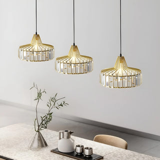 Three gold K9 crystal pendant lights illuminating a dining table in a bright modern interior