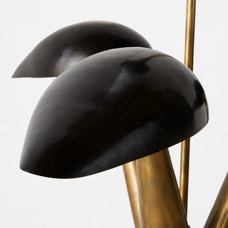 Close-up of the curved black dome shades and brass arms of the Trombara mid-century chandelier