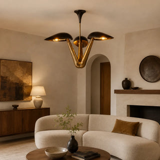 Trombara brass dome chandelier lighting a mid-century living room with a curved boucle sofa and stone fireplace