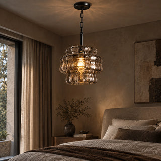 Vellori textured glass pendant light suspended beside a bed in a warm neutral bedroom