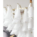 Close-up of handcrafted frosted glass elements with brass frame on Velmira chandelier
