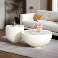 Set of two white round coffee tables with gold bases and marble tops in modern beige living room