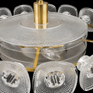Close-up of the clear textured glass diffuser and brass frame of the Vetrara chandelier