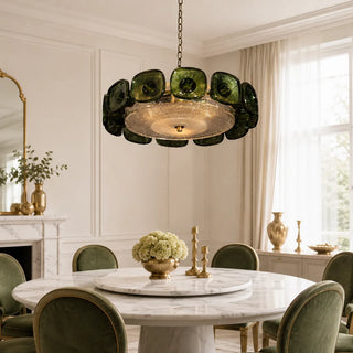 Green Vetrara ring chandelier above a marble table with green velvet chairs in an elegant dining room