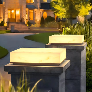 Elegant marble-finish electric pillar lights illuminating a villa driveway and garden entrance at night